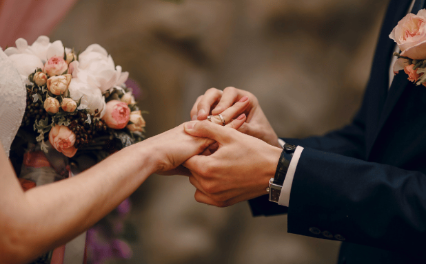 A close-up of a couple exchanging rings during their wedding ceremony. Bryn Mawr Jewelry: the best place to buy wedding rings. Shop online or in-store.