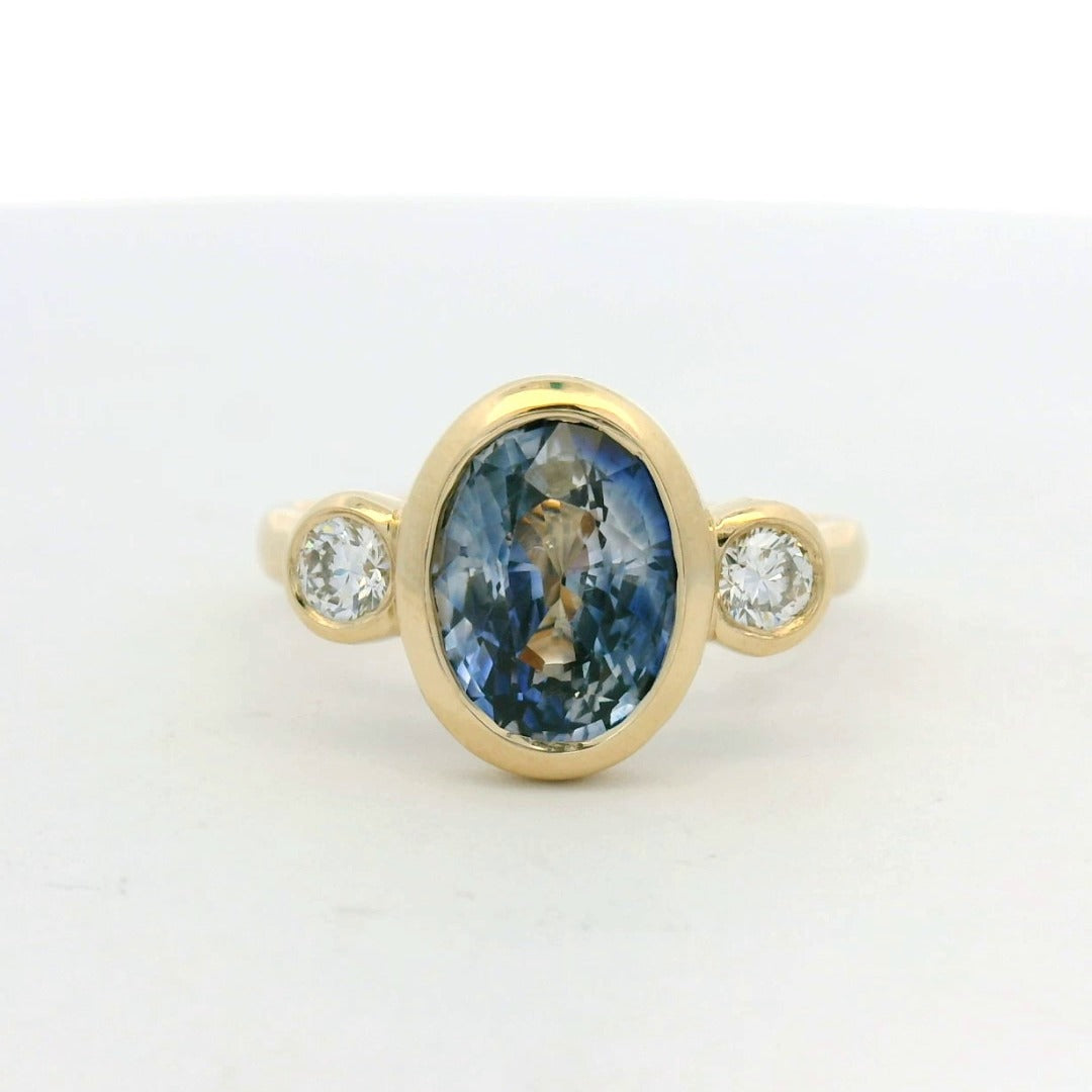 14KT yellow gold bezel set three stone sapphire and diamond engagement ring