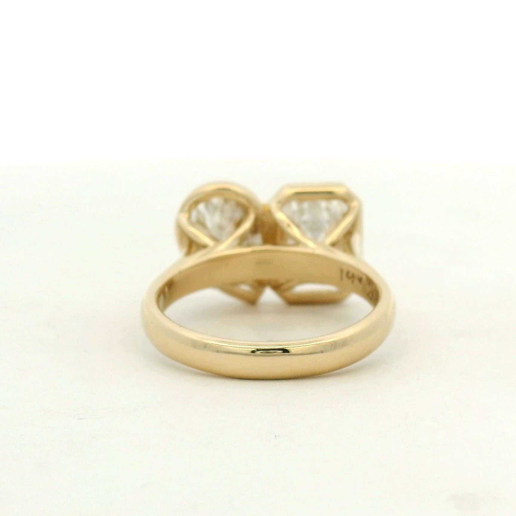 14k yellow gold toi et moi style engagement ring with an emerald and a pear cut diamond