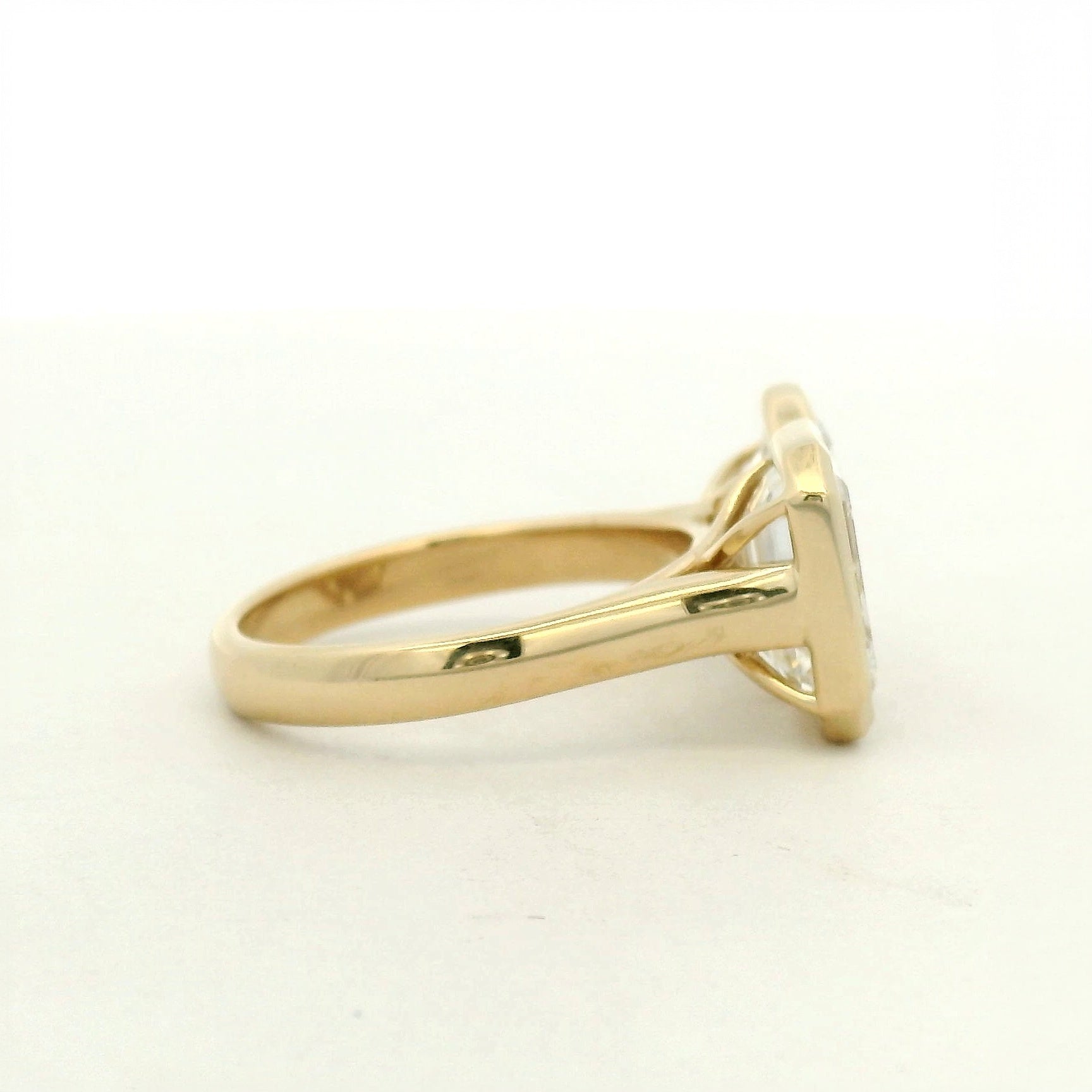 14k yellow gold toi et moi style engagement ring with an emerald and a pear cut diamond