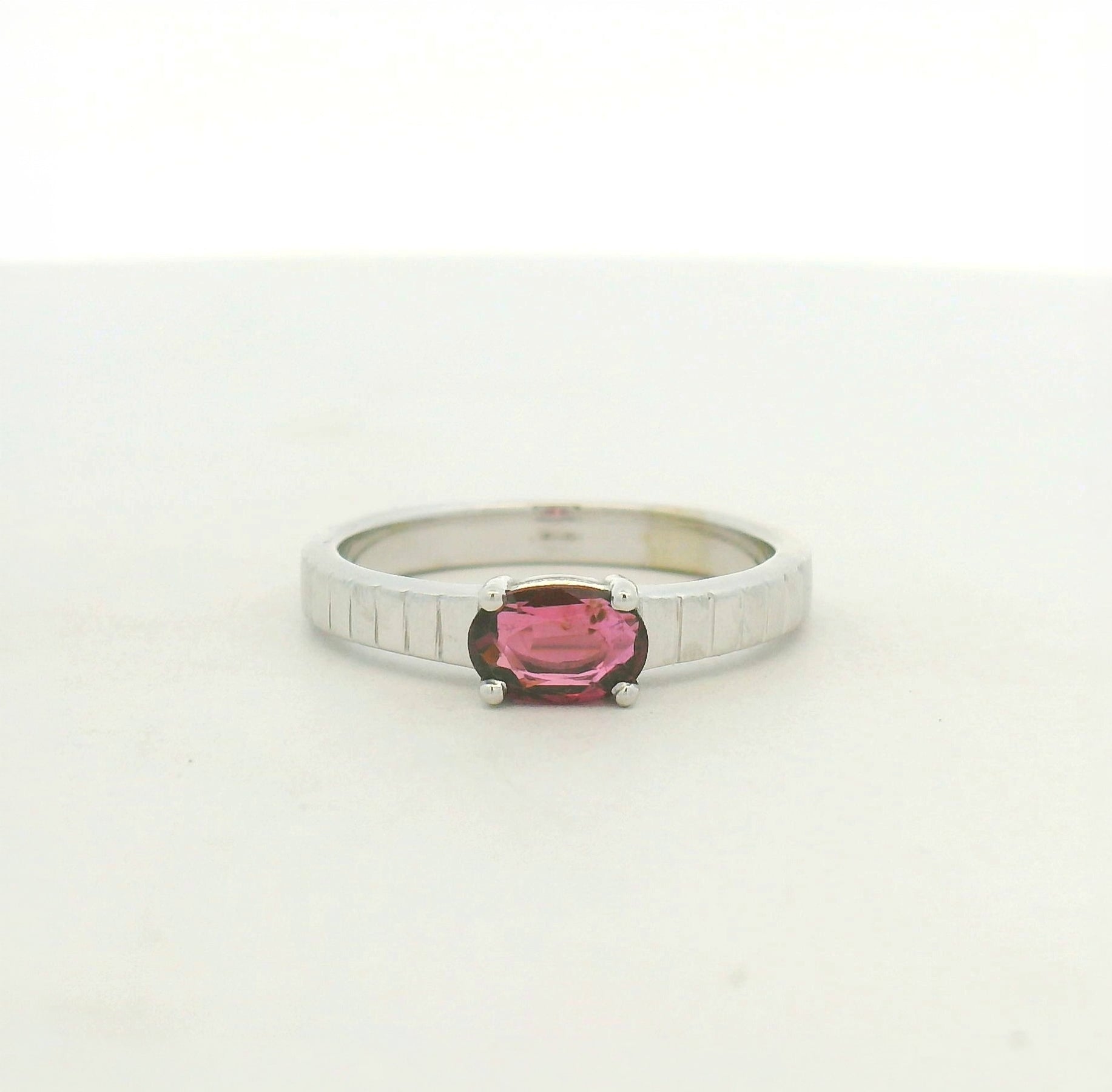 14kt white gold east west set ruby with banded texture on shank