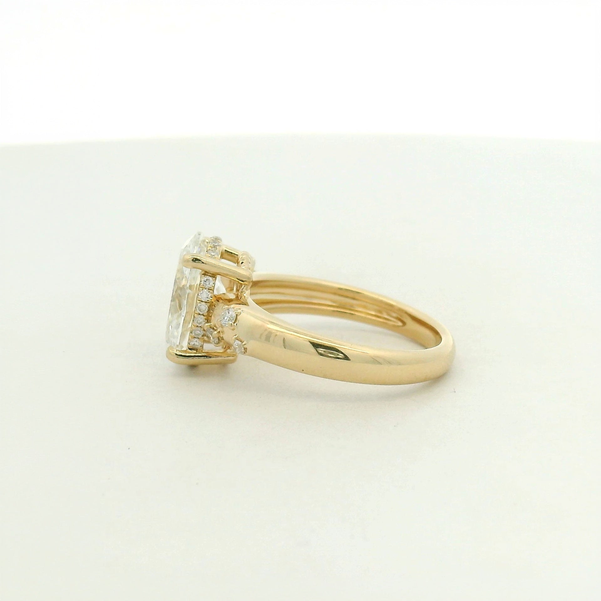 14kt yellow gold with a large center oval and asymetrical mellie side stones