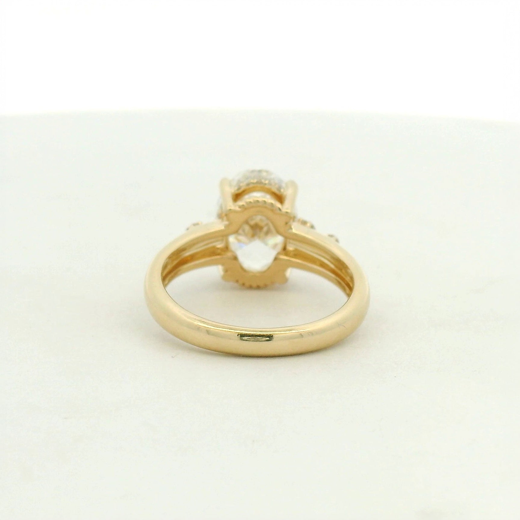 14kt yellow gold with a large center oval and asymetrical mellie side stones