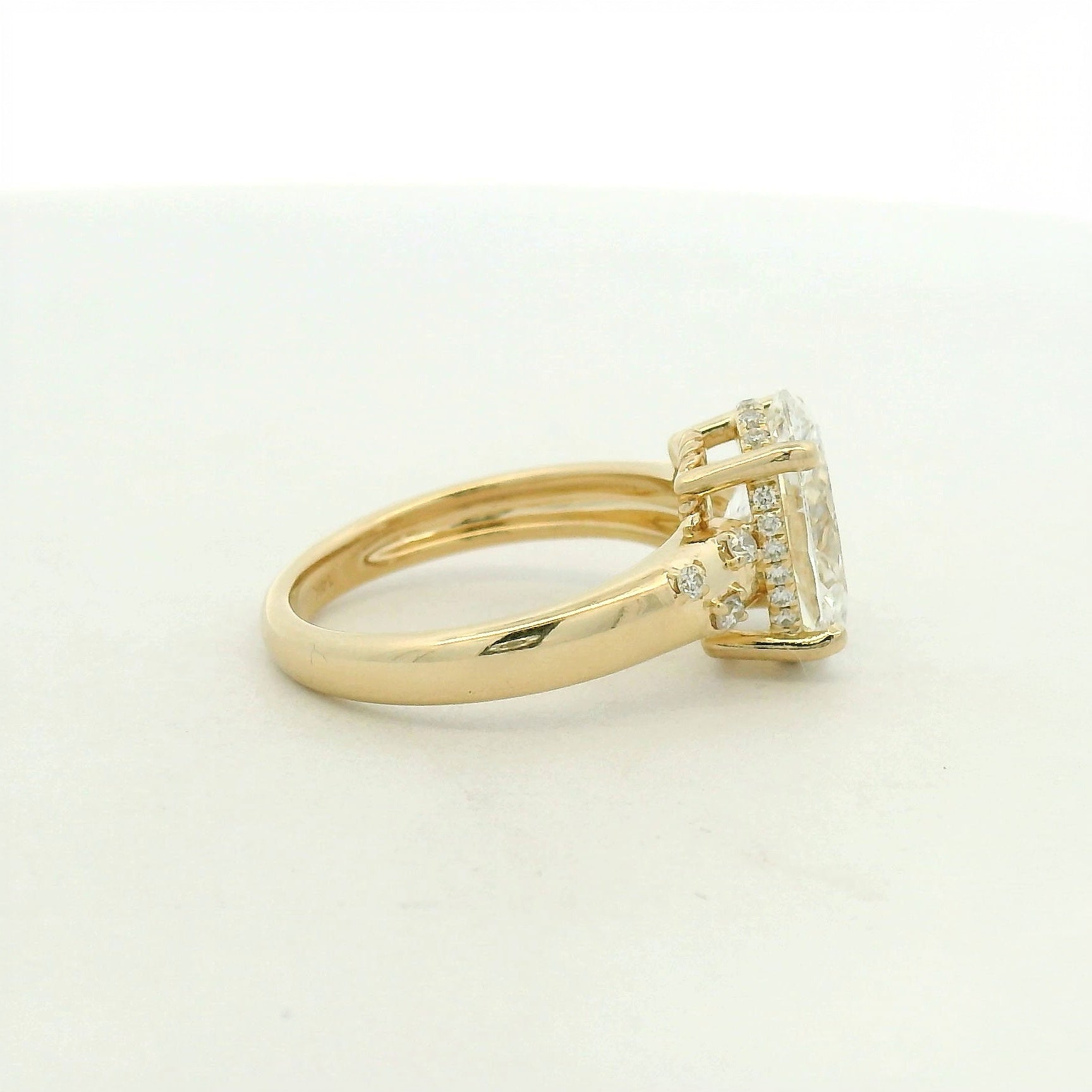 14kt yellow gold with a large center oval and asymetrical mellie side stones