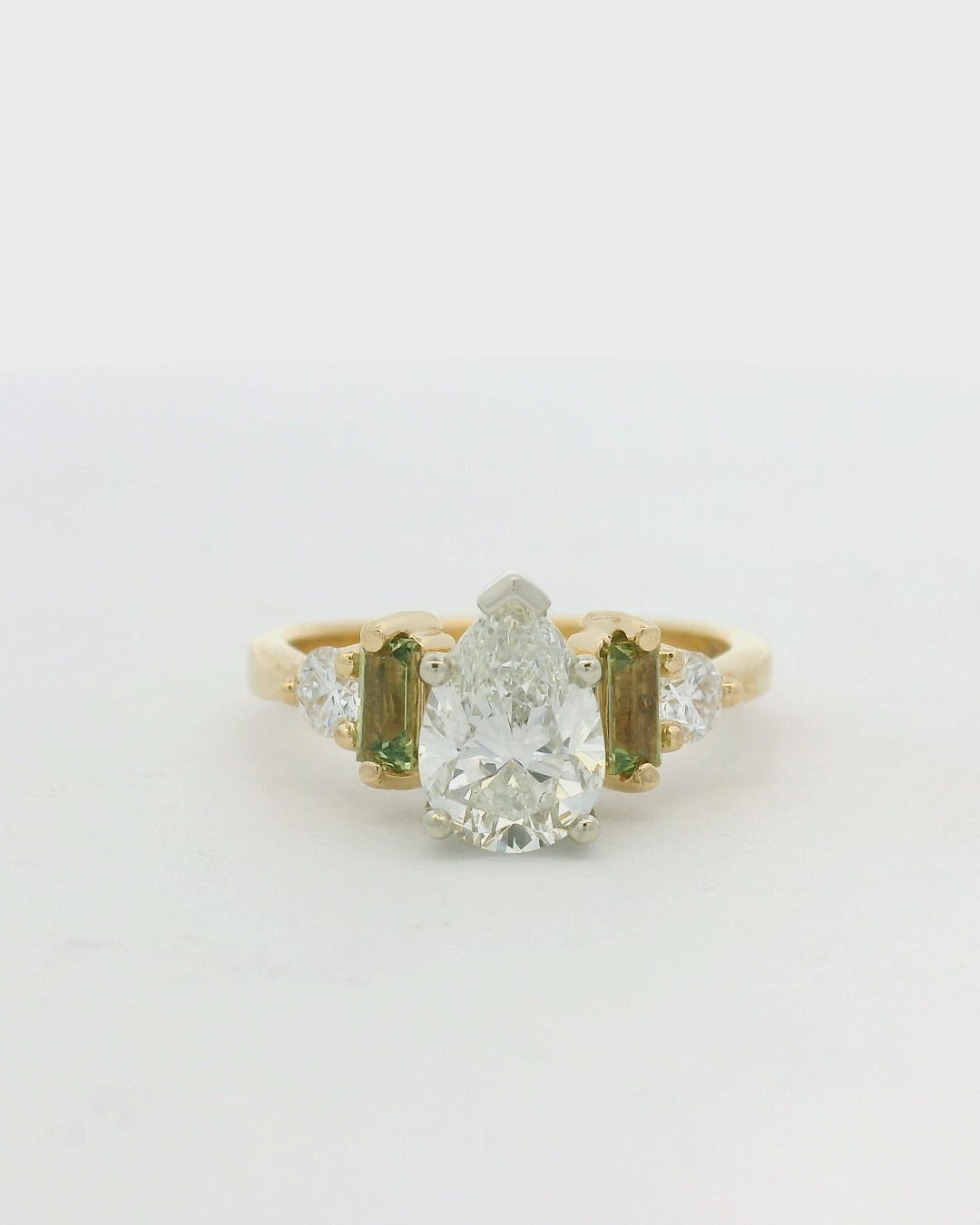 14KT two tone pear diamond with green sapphire and diamond side stones engagement ring