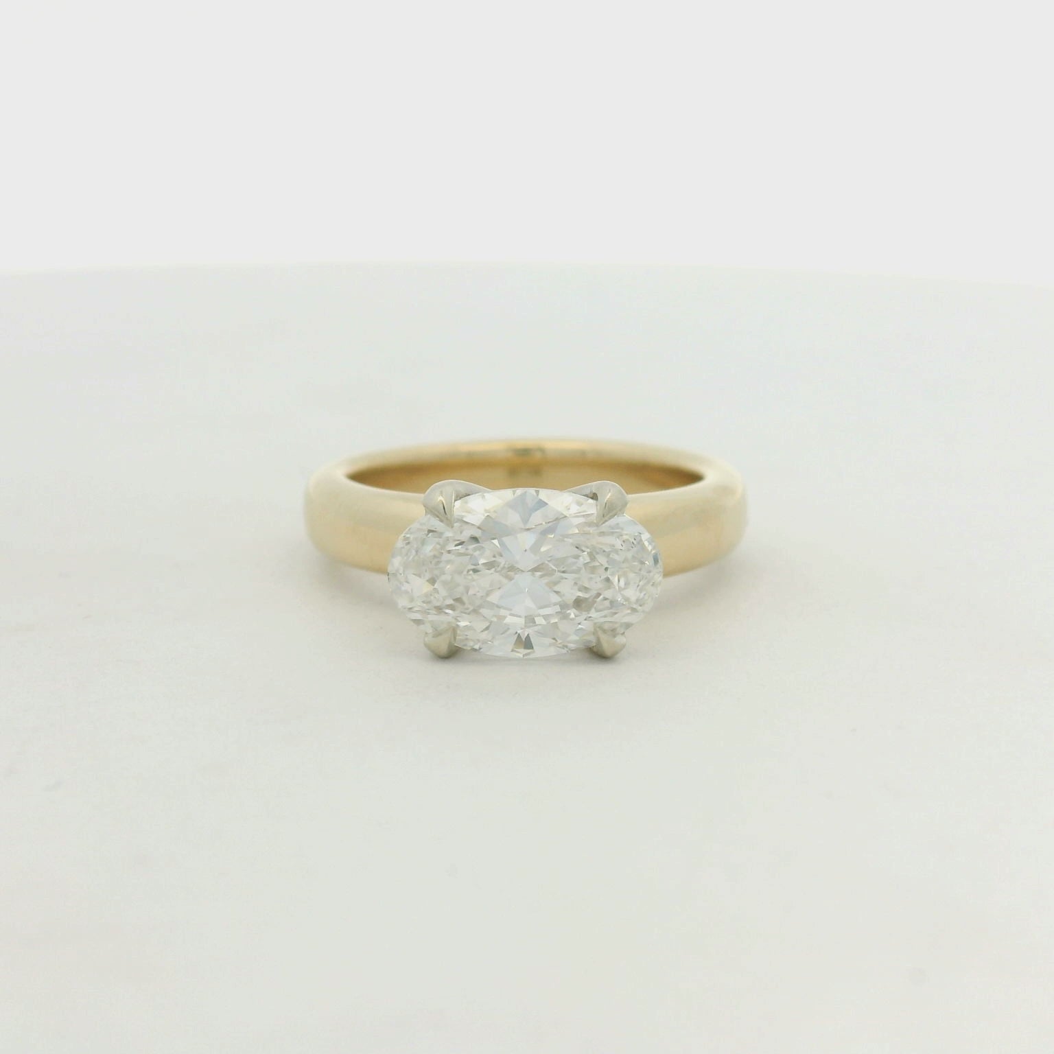14kt yg band with 14k wg head east west oval prong set