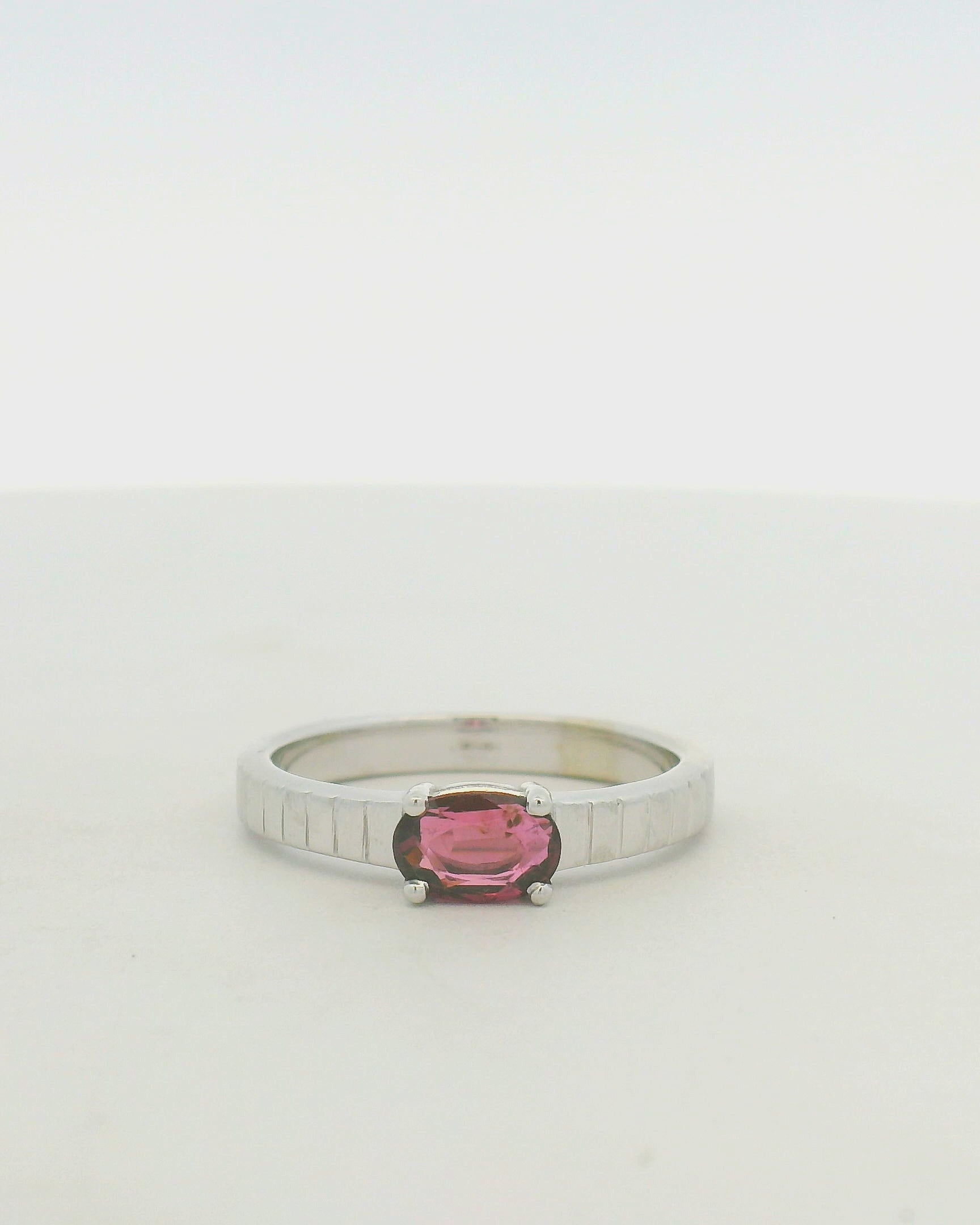 14kt white gold east west set ruby with banded texture on shank