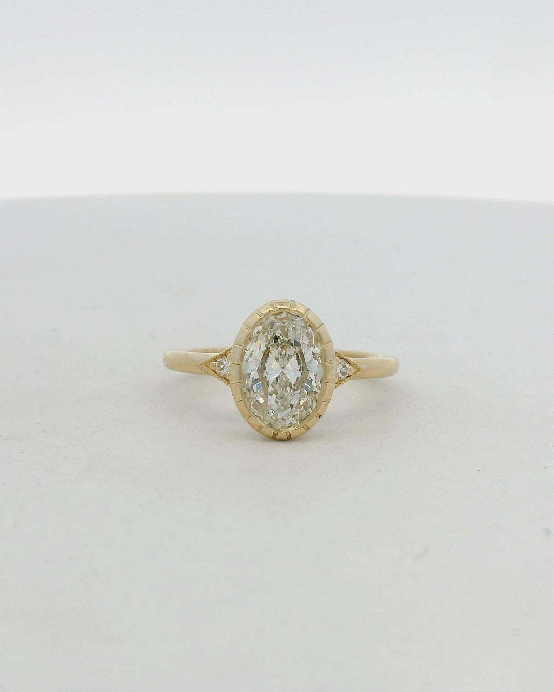 14KT yellow gold oval bezel set side stone engagement ring